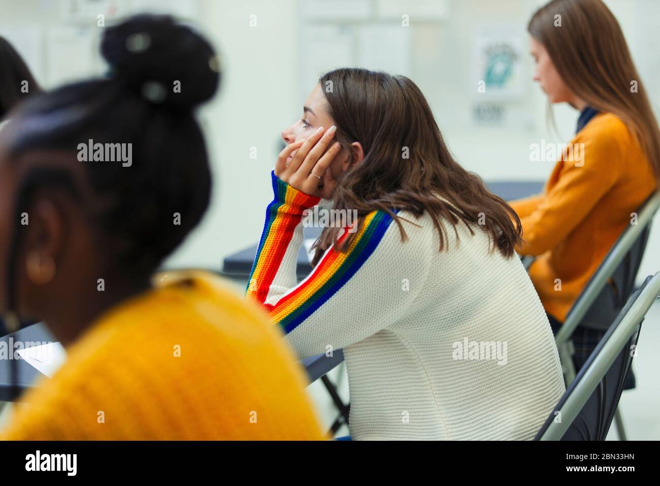 Une jeune fille d'école secondaire qui se présente à un examen à un bureau en classe Banque D'Images