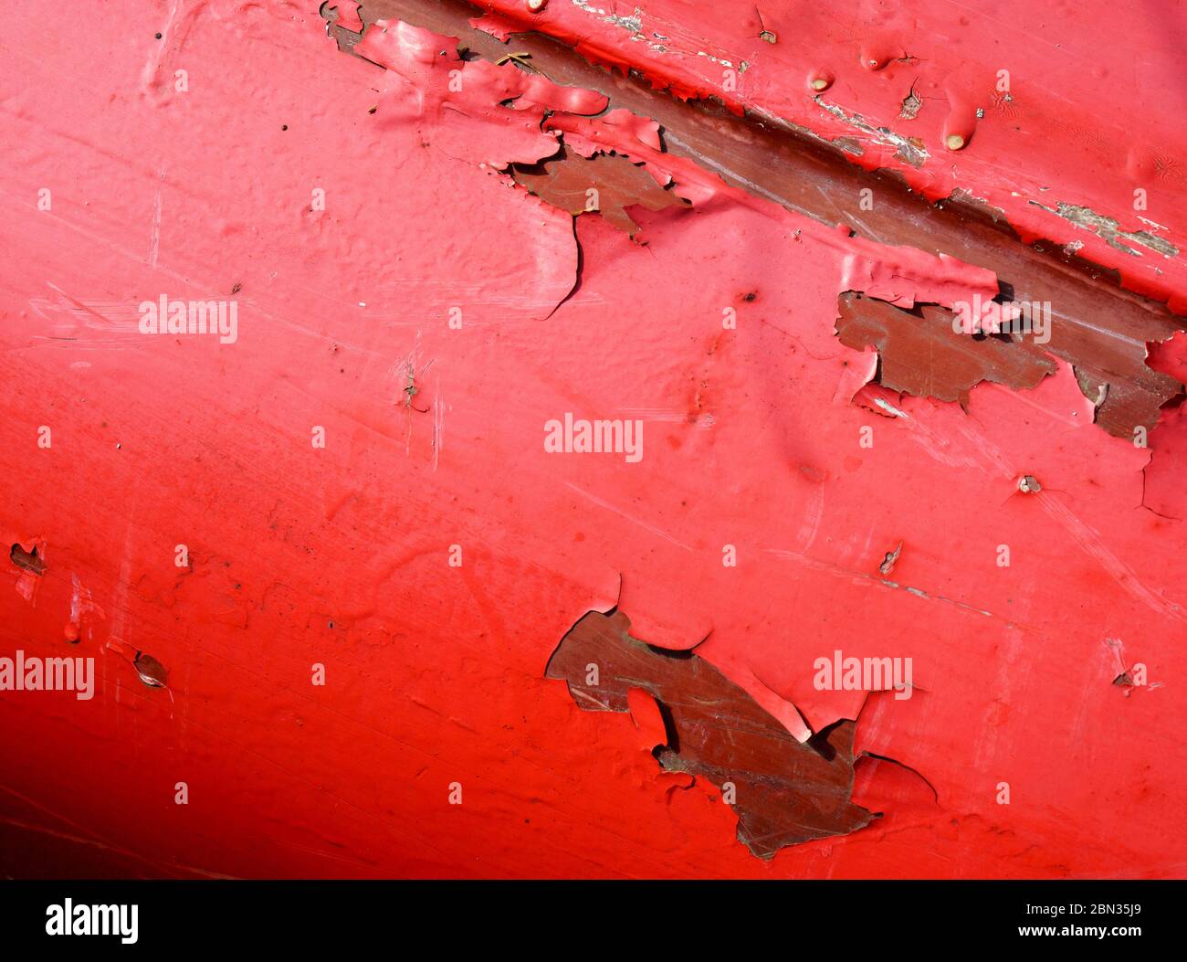 Peinture rouge écaillée sur le fond en fibre de verre du canot Banque D'Images
