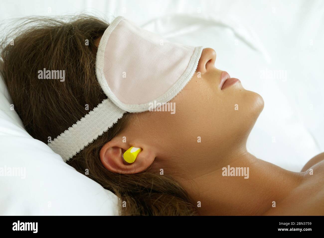 La femme porte un masque oculaire et utilise des bouchons d'oreille pour un  meilleur sommeil Photo Stock - Alamy