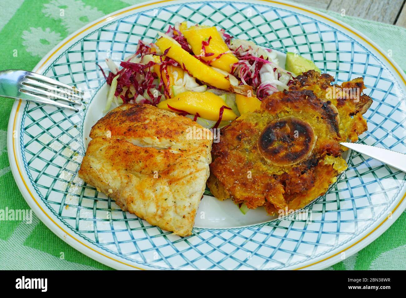 Un plat de poisson noirci avec des pierres de plantain Banque D'Images