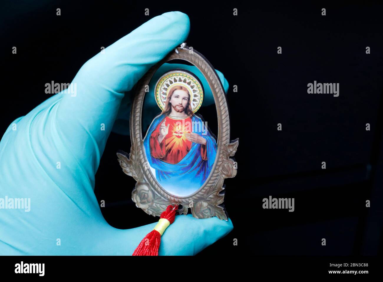 Épidémies de coronavirus ( Covid-19 ). catholique priant le rosaire avec un gant protecteur. Banque D'Images