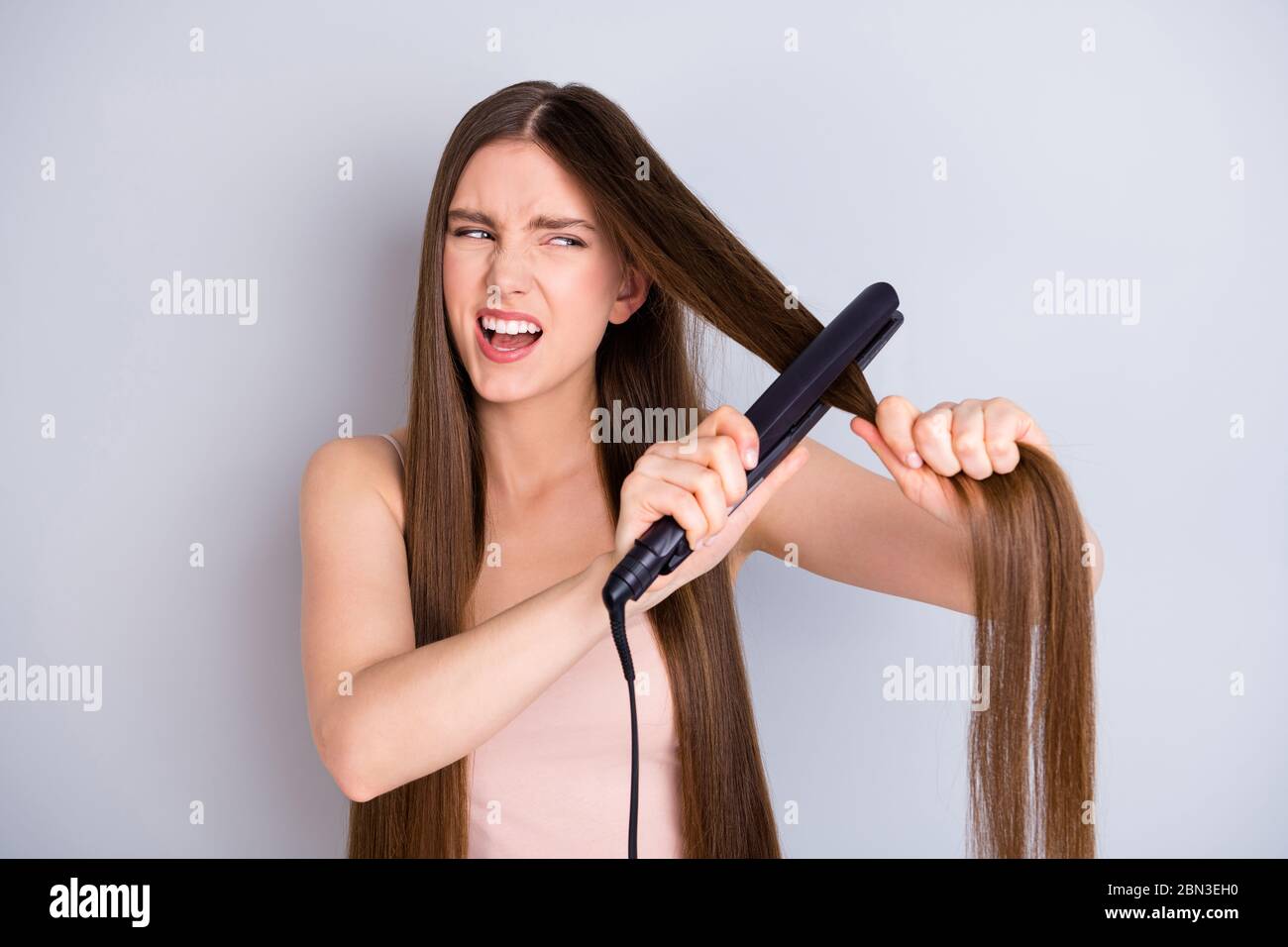 Gros plan portrait de sa belle-apparence attrayante briller fou dévasté irritée fille brun-cheveux redressant lissage tirer Banque D'Images