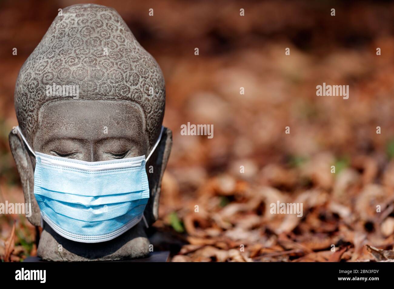 Épidémie de coronavirus (COVID-19). Bouddha statue blanc masque médical. Banque D'Images