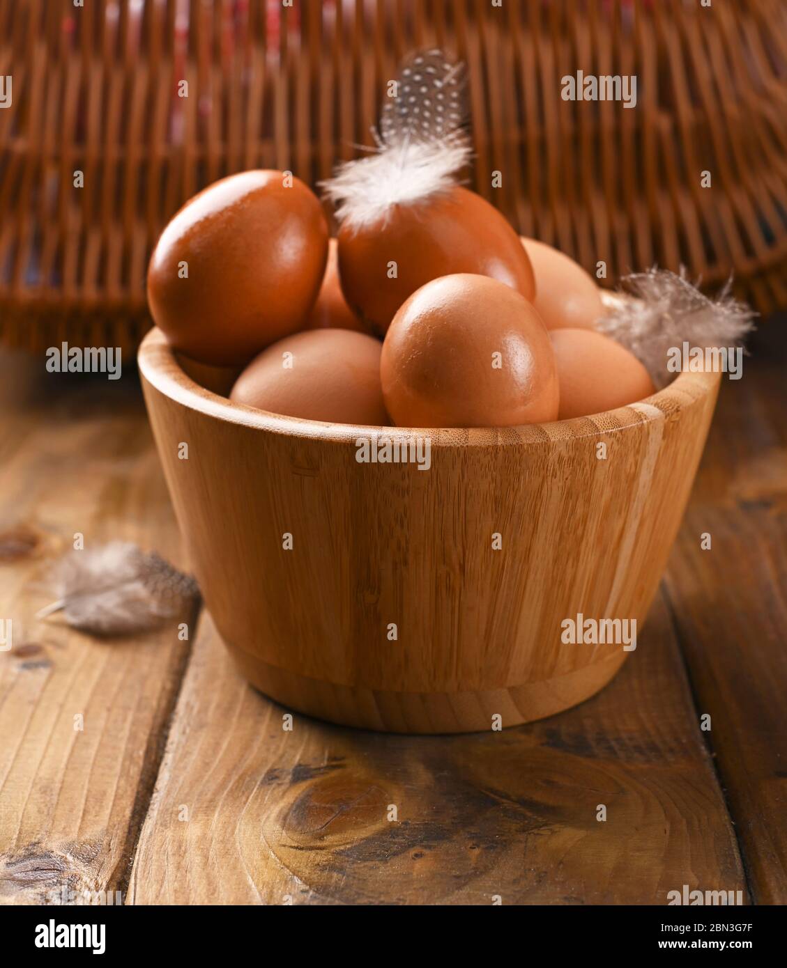 œufs rustiques, de poulets faits maison, sur un fond en bois, avec des plumes. Aliments écologiques, aliments propres. Photo vintage. Le concept de la nourriture naturelle. Copier l'espace. Banque D'Images