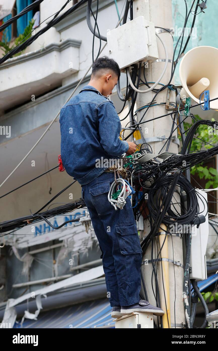 Électricien d'entretien réparant le pylône électrique. Quy Nhon. Vietnam. Banque D'Images