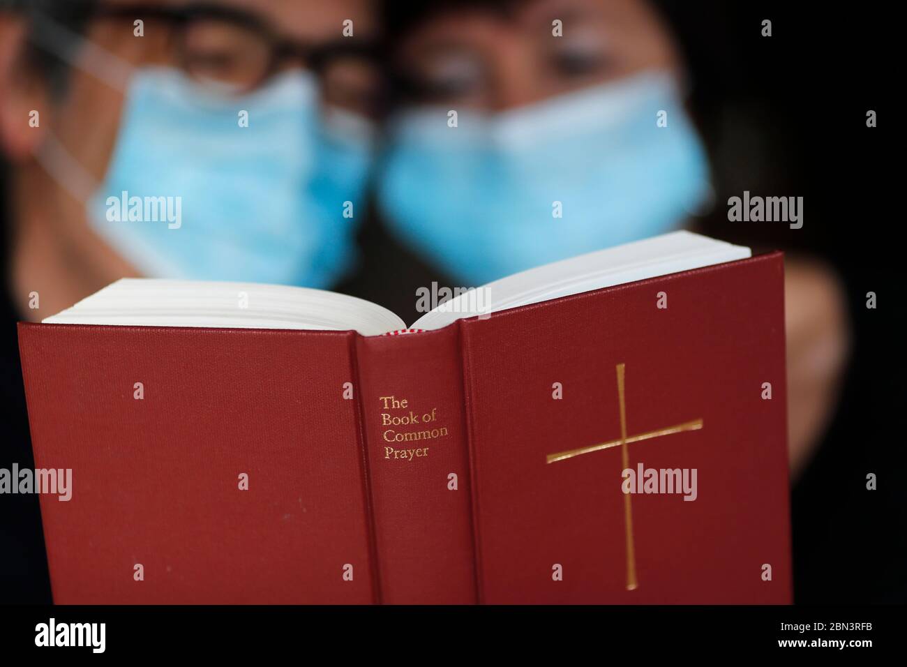 Homme et femme lisant la bible avec un masque jetable pour éviter le coronavirus contagieux ( COVID-19). France. Banque D'Images