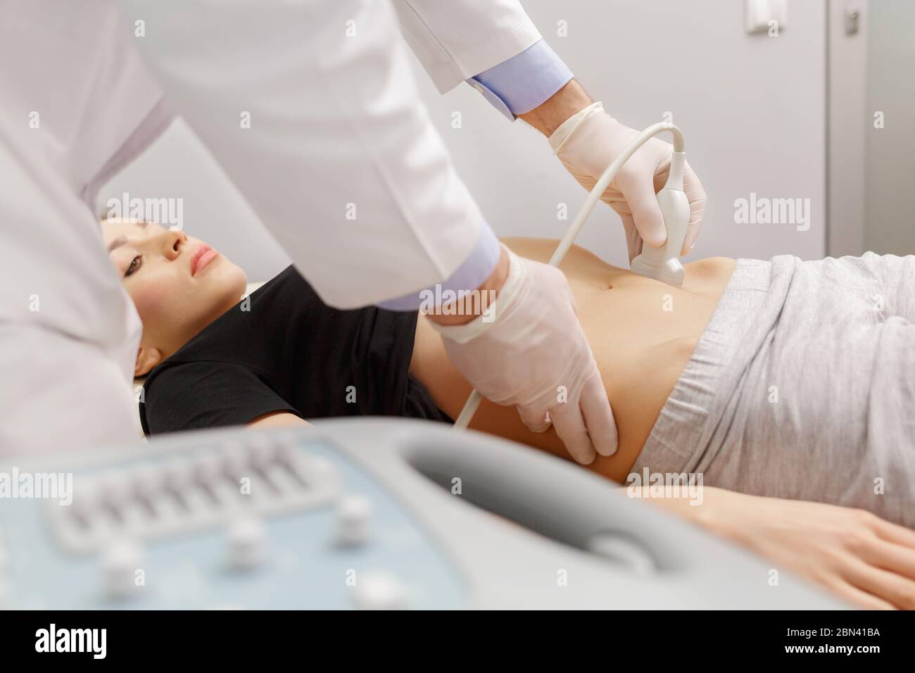 Médecin effectuant un examen échographique des organes abdominaux du patient dans son bureau. Jeune femme passant une échographie en clinique. Travail de médecin. Médical Banque D'Images