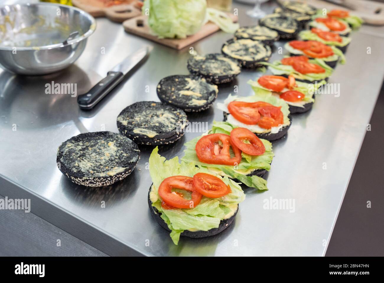 Lot de hamburgers noirs non finis en attente de bœuf haché Banque D'Images