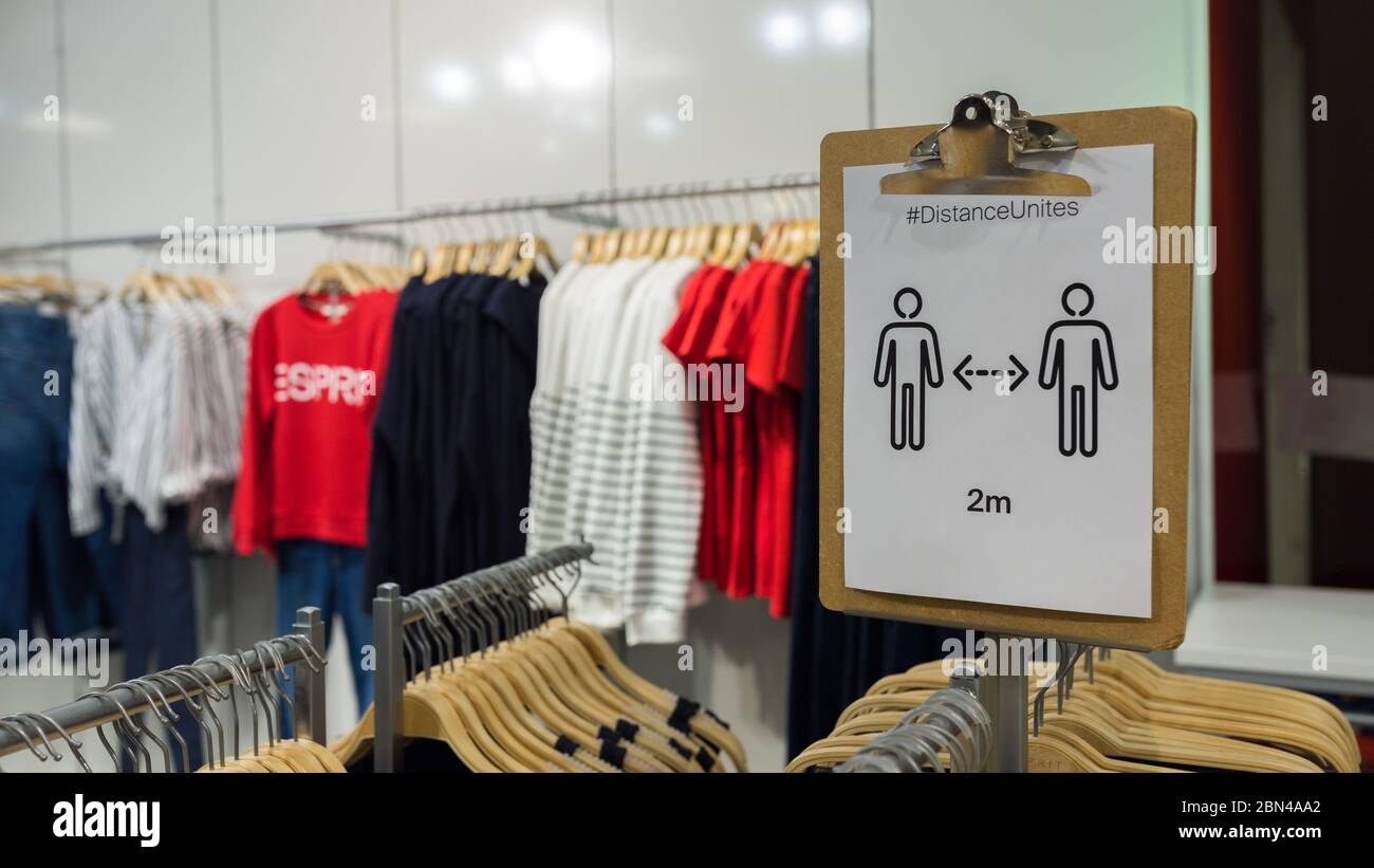 Conservez l'affiche de distance dans un magasin Esprit. Vêtements en arrière-plan. Le détaillant de mode a lancé une procédure de protection. Banque D'Images