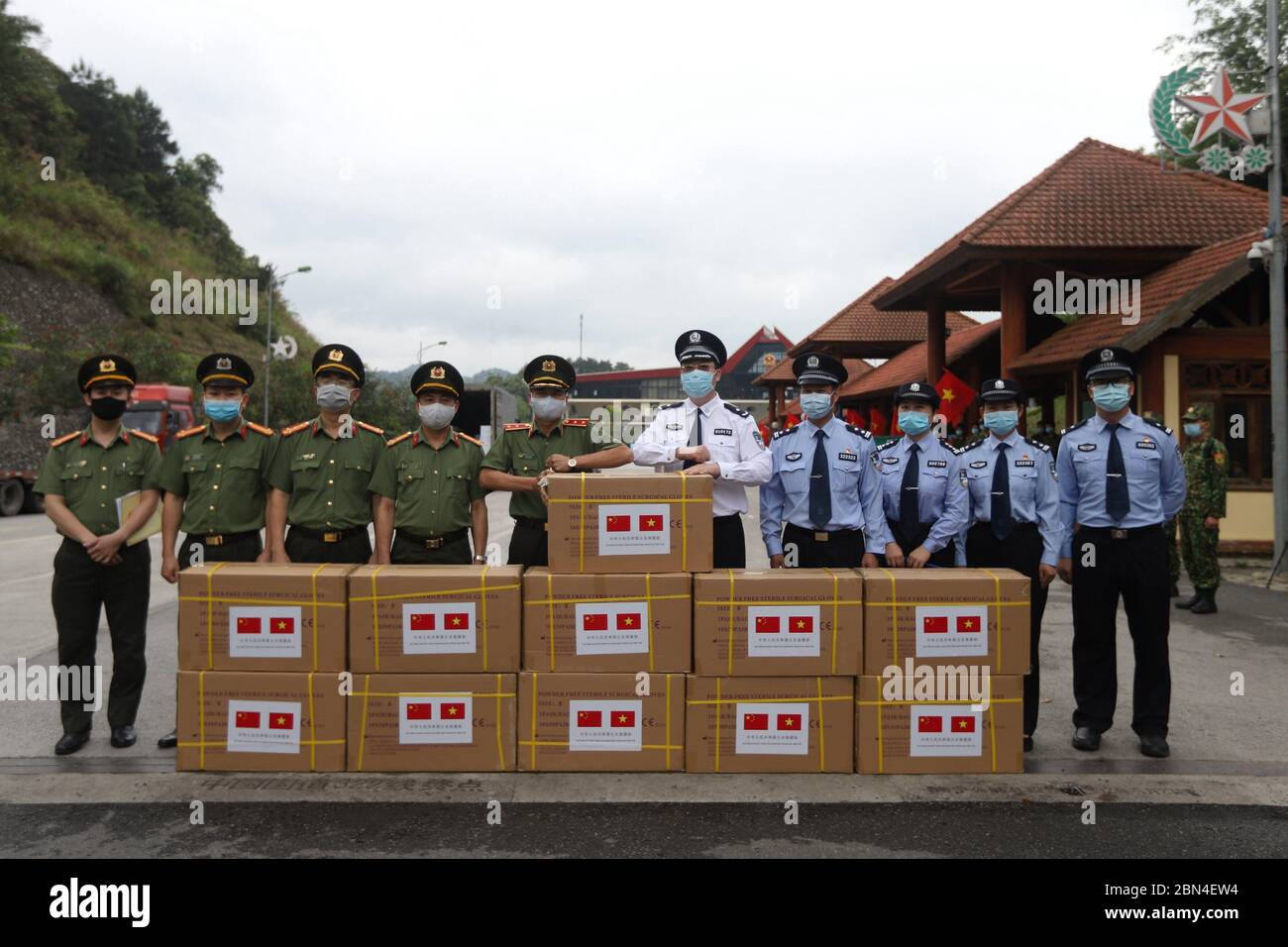 (200512) -- HANOÏ, le 12 mai 2020 (Xinhua) -- des représentants de la Chine et du Vietnam posent pour une photo de groupe avec les matériaux de prévention et de contrôle de la COVID-19 à un passage frontalier entre la Chine et le Vietnam, le 12 mai 2020. Mardi, le ministère chinois de la sécurité publique a fait don de matériel de prévention et de contrôle COVID-19 au ministère vietnamien de la sécurité publique. Ces matériaux, y compris les masques KN95, les masques chirurgicaux jetables, les combinaisons de protection médicale, les gants et les lunettes, ont été livrés à un passage frontalier entre les deux pays. (Ambassade de Chine au Vietnam/document via Xinhua) Banque D'Images