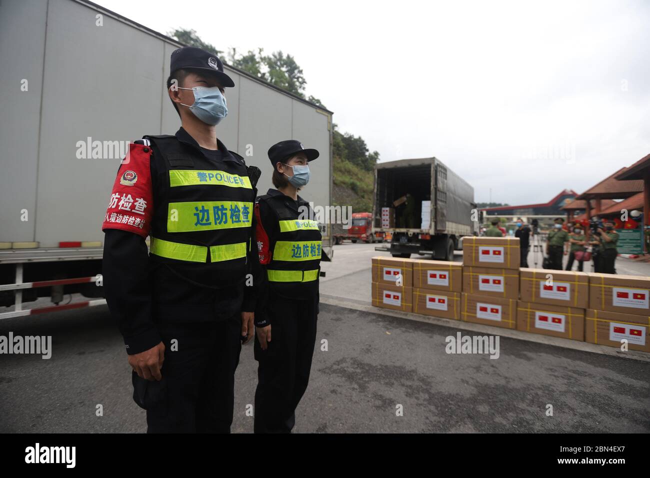 (200512) -- HANOÏ, le 12 mai 2020 (Xinhua) -- des policiers sont vus devant des camions transportant des matériaux de prévention et de contrôle COVID-19 à un poste frontalier entre la Chine et le Vietnam, le 12 mai 2020. Mardi, le ministère chinois de la sécurité publique a fait don de matériel de prévention et de contrôle COVID-19 au ministère vietnamien de la sécurité publique. Ces matériaux, y compris les masques KN95, les masques chirurgicaux jetables, les combinaisons de protection médicale, les gants et les lunettes, ont été livrés à un passage frontalier entre les deux pays. (Ambassade de Chine au Vietnam/document via Xinhua) Banque D'Images