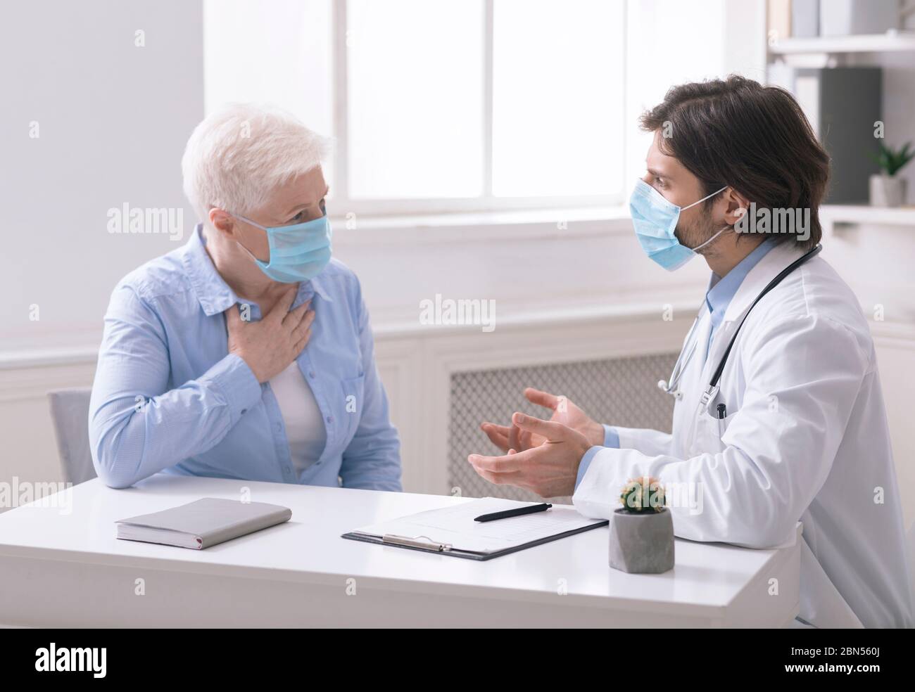 Médecin consultant une femme âgée avec toux, au bureau Banque D'Images