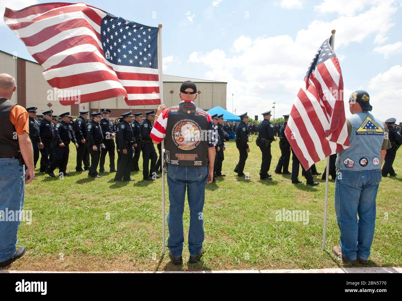 Austin, Texas États-Unis, 12 avril 2012: Les vétérans militaires portant des drapeaux américains sont à l'attention pendant qu'ils paient tribune à l'officier de police d'Austin Jaime Padron, tué dans l'exercice de leurs fonctions, à ses funérailles. ©Marjorie Kamys Cotera/Daemmrich Photographie Banque D'Images