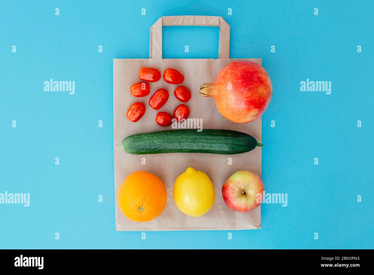 Fruits et légumes sur un sac en papier sur fond bleu. Concept alimentation saine. Livraison de nourriture, boutique en ligne. Acheter des produits en ligne pendant la quarantaine. Banque D'Images