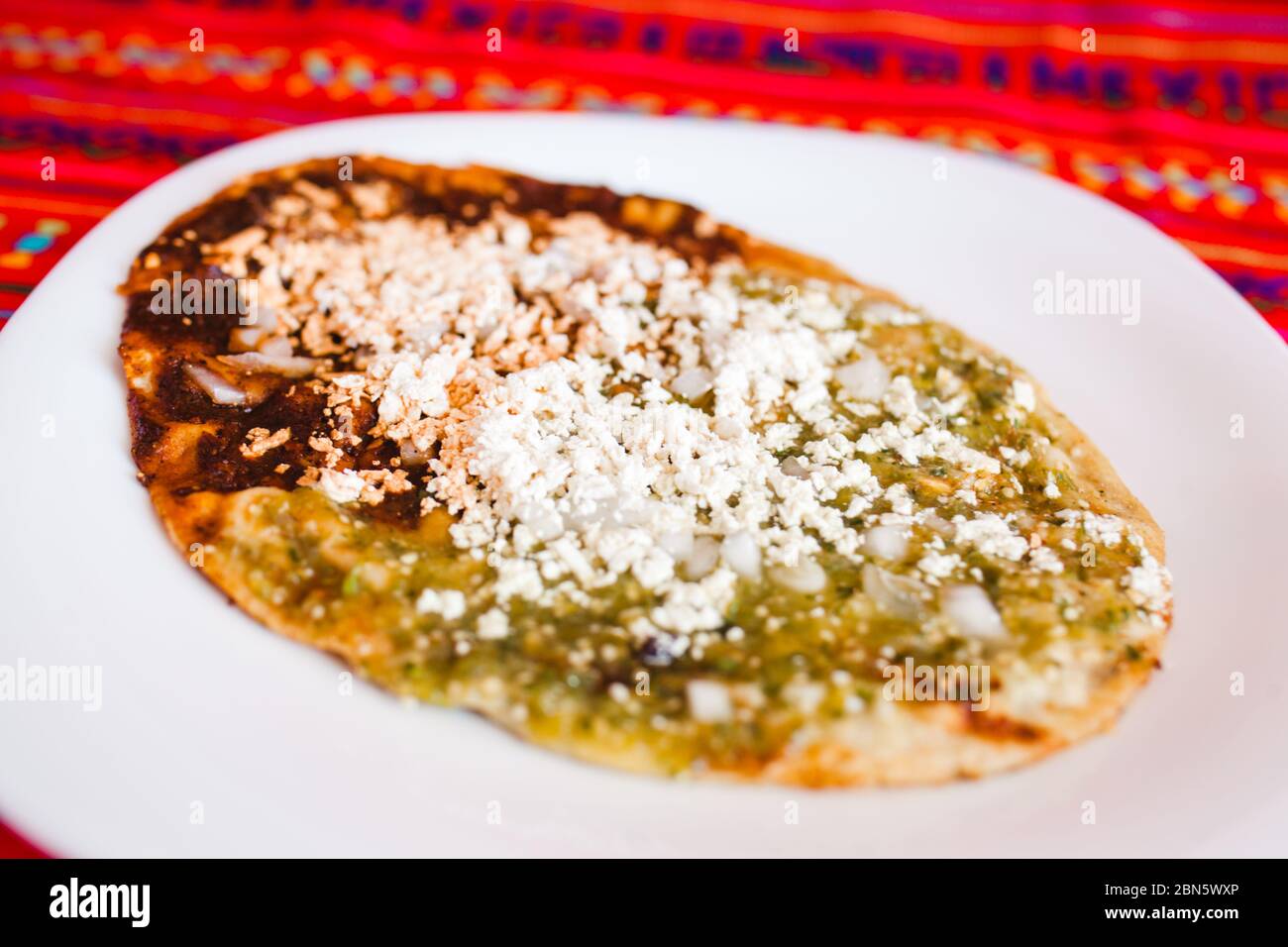 Sopes mexicains au fromage râpé et à la salsa verte, cuisine mexicaine épicée au mexique Banque D'Images