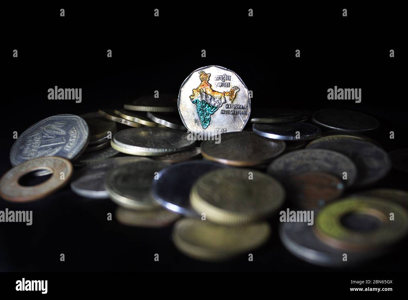 Deux roupies de l'Inde isolées sur fond noir. Carte de l'Inde comme symbole de l'intégration nationale indienne représentée dans les pièces de monnaie indiennes. Banque D'Images