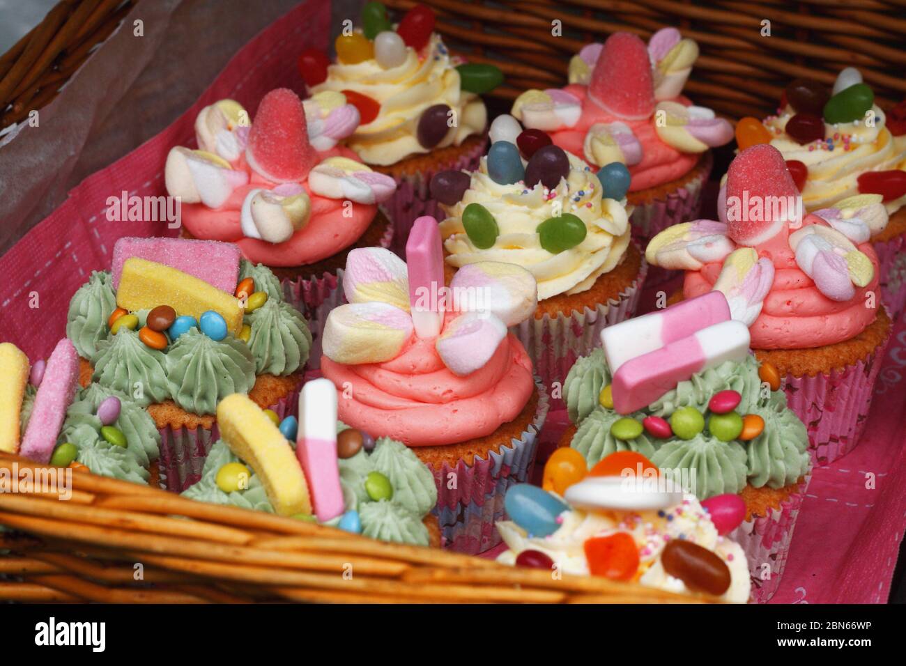 Des Rangees De Petits Gateaux Colores Alignes Dans Un Panier Avec Des Guimauves Et Des Bonbons Pour La Decoration Photo Stock Alamy