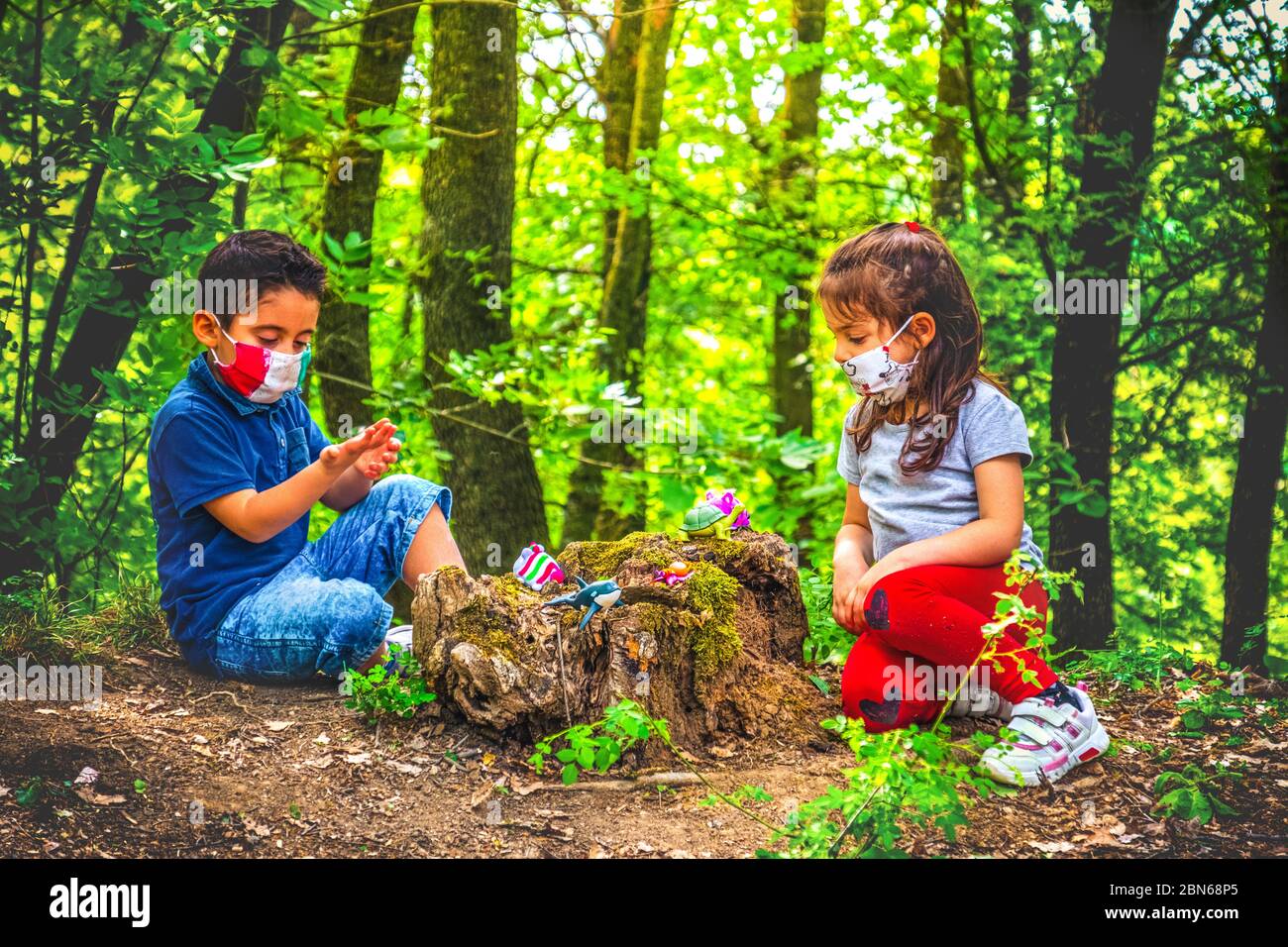 nouveau fond normal de coronavirus - enfant jouer masque de visage et de social distanciation dans la forêt pour éviter les rassemblements Banque D'Images