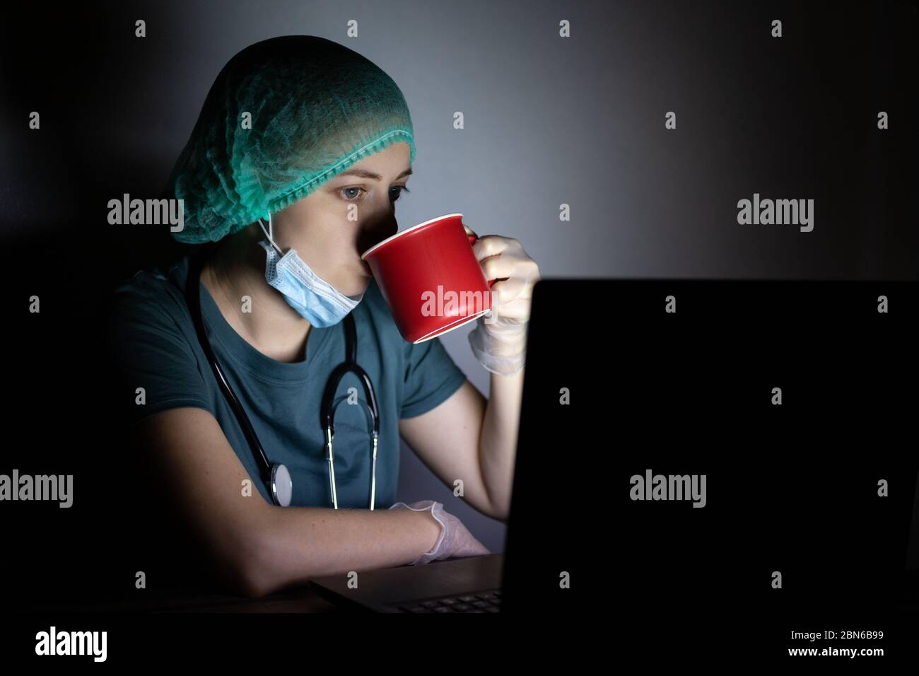 Femme caucasienne médecin infirmière dans le masque chirurgical semble fatigué, épuisé la nuit à cause de covid Banque D'Images