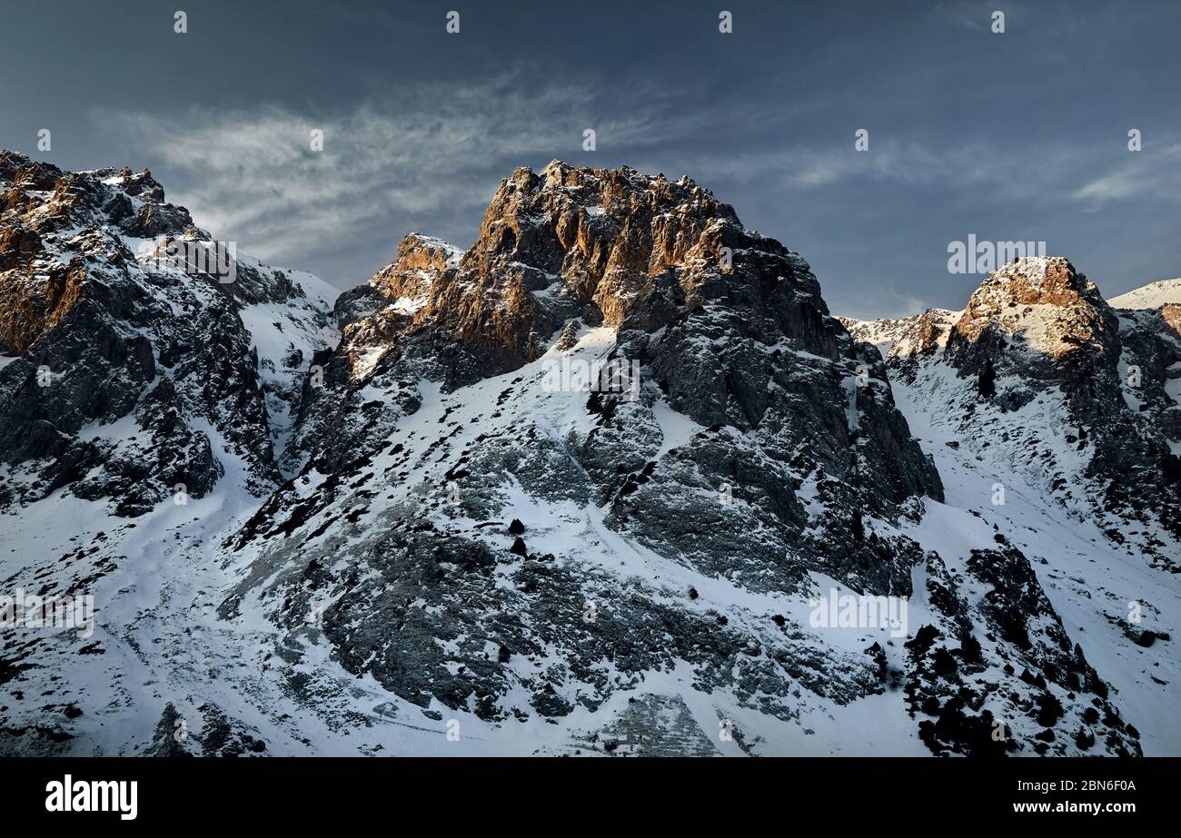 Lever du Soleil à de hautes montagnes avec de la neige sur fond de ciel bleu à l'heure d'hiver au Kazakhstan Banque D'Images
