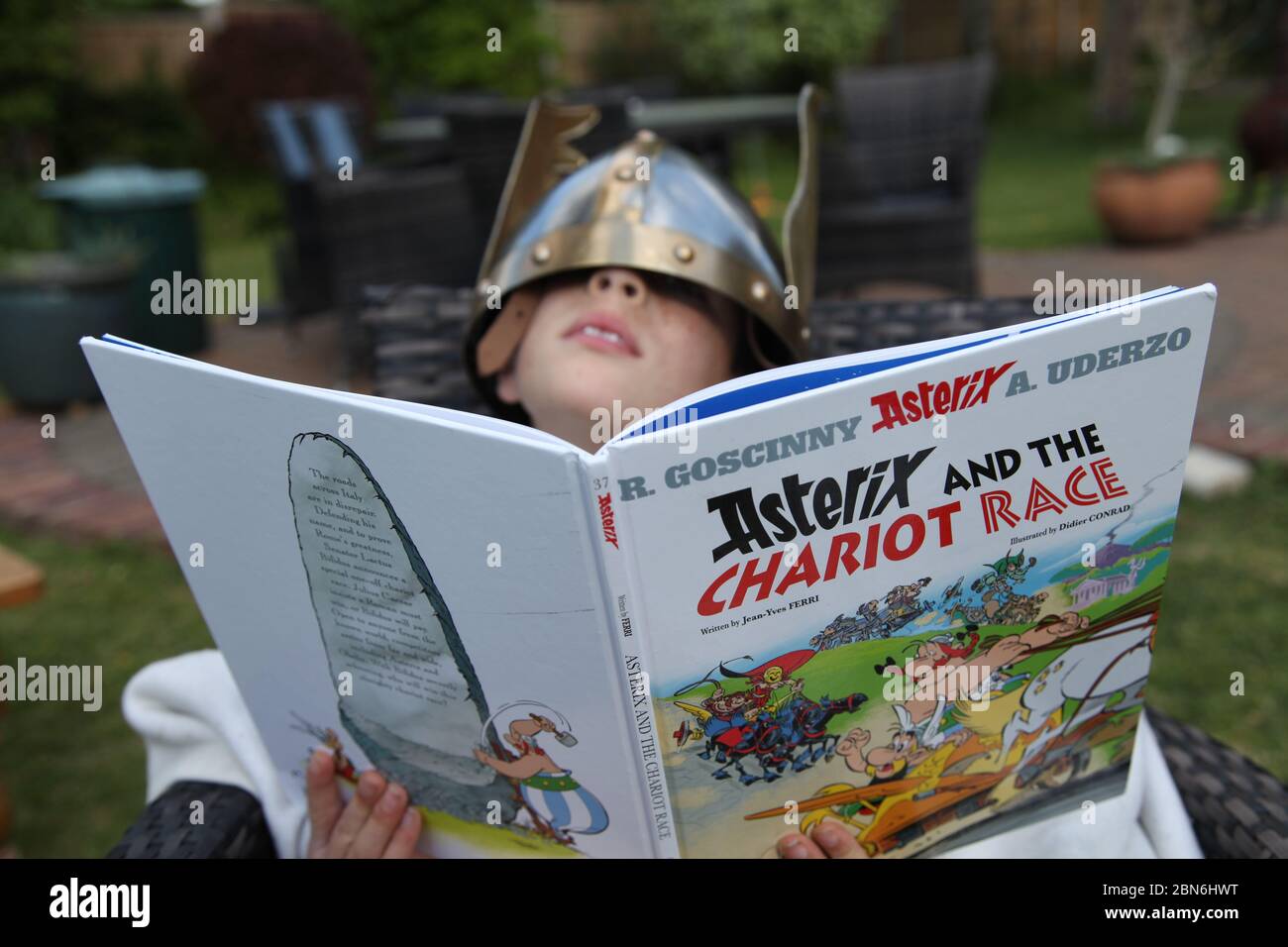 Astérix et le livre pour enfants de la course Chariot lu par un jeune  garçon en casque à oreilles trop grand, couverture de livre, version  anglaise du Royaume-Uni Photo Stock - Alamy