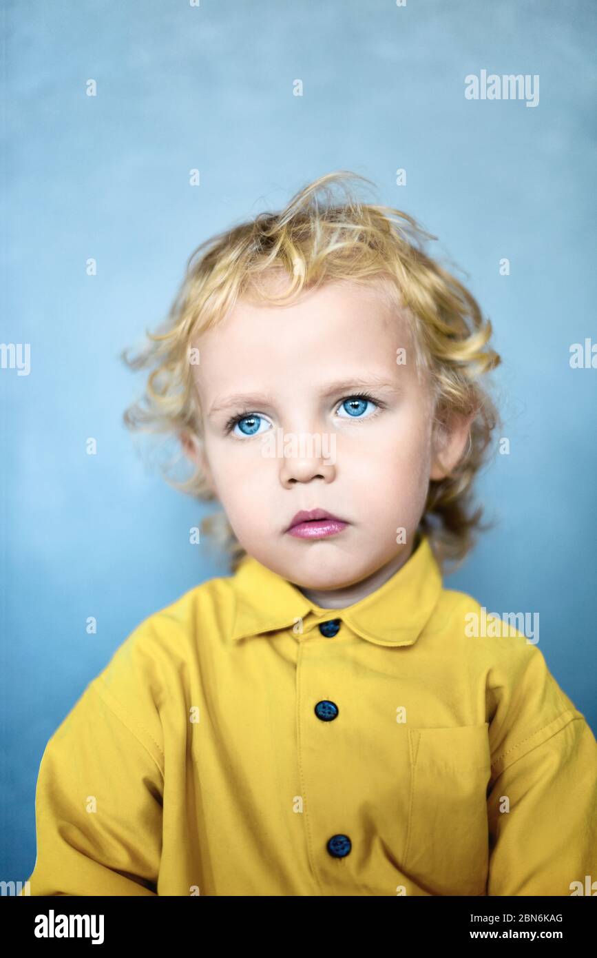 Adorable petit garçon doux avec des cheveux dorés et des yeux bleus Banque D'Images