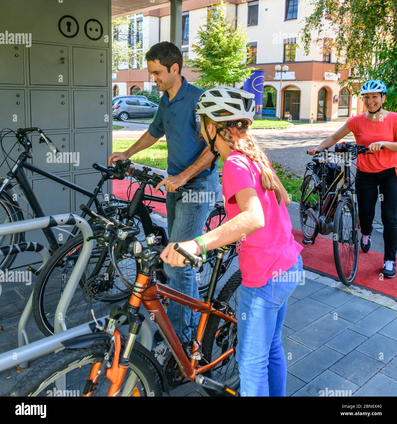 Une famille bien-huppée utilise un concept de parking à vélo exemplaire pour une promenade en ville à pied Banque D'Images