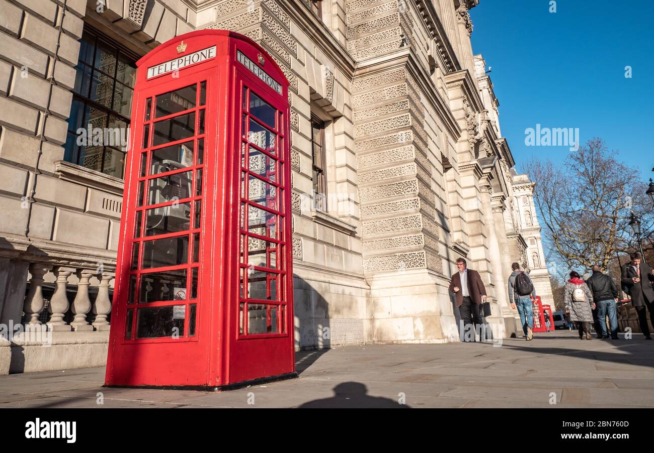 Téléphone Red. Un ancien téléphone britannique traditionnel rouge à l'extérieur de l'un des nombreux bâtiments gouvernementaux de Whitehall, Londres. Banque D'Images