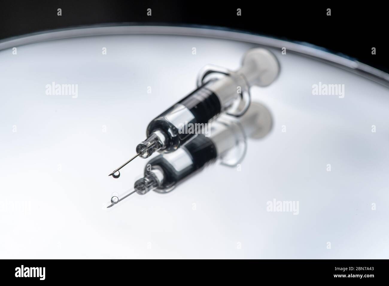 Seringue en verre avec réflexion sur fond blanc. Concept du vaccin contre le coronavirus ou COVID-19. Banque D'Images