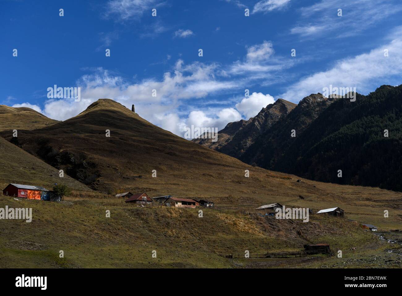 Caucase, Géorgie, région de Tusheti, Dartlo. Tour médiévale au sommet d'un paysage de montagne avec des maisons dans la vallée de la région de Tusheti Banque D'Images
