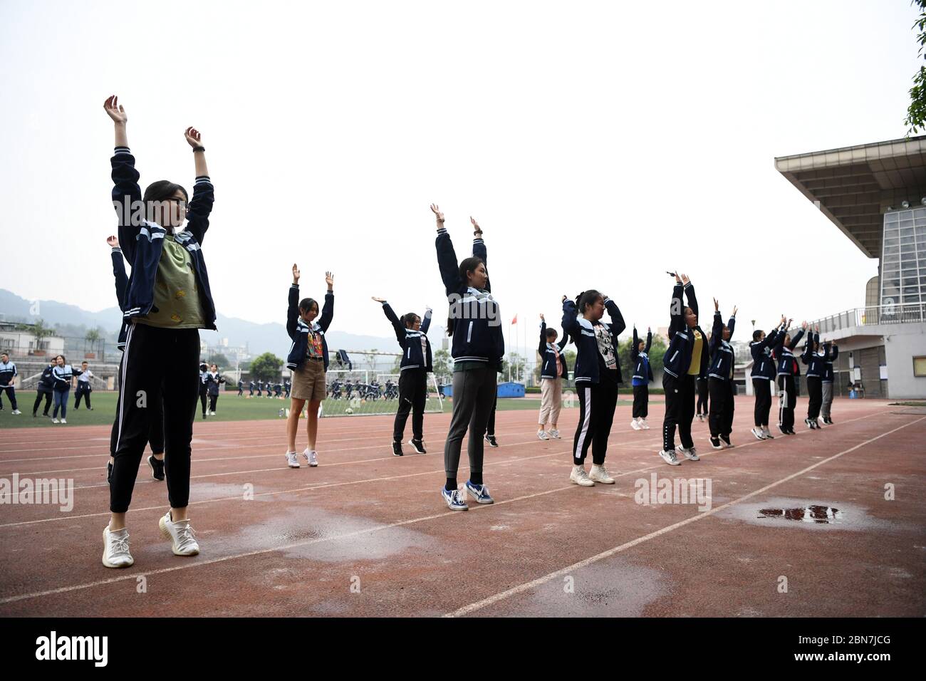Chongqing. 13 mai 2020. Les élèves s'échauffent lors d'un cours de gymnastique dans une école secondaire dans la municipalité de Chongqing, dans le sud-ouest de la Chine, le 13 mai 2020. Les écoles de Chongqing ont progressivement repris des cours de gymnastique, avec une protection adéquate contre les épidémies pour les élèves. Crédit: Tang Yi/Xinhua/Alay Live News Banque D'Images