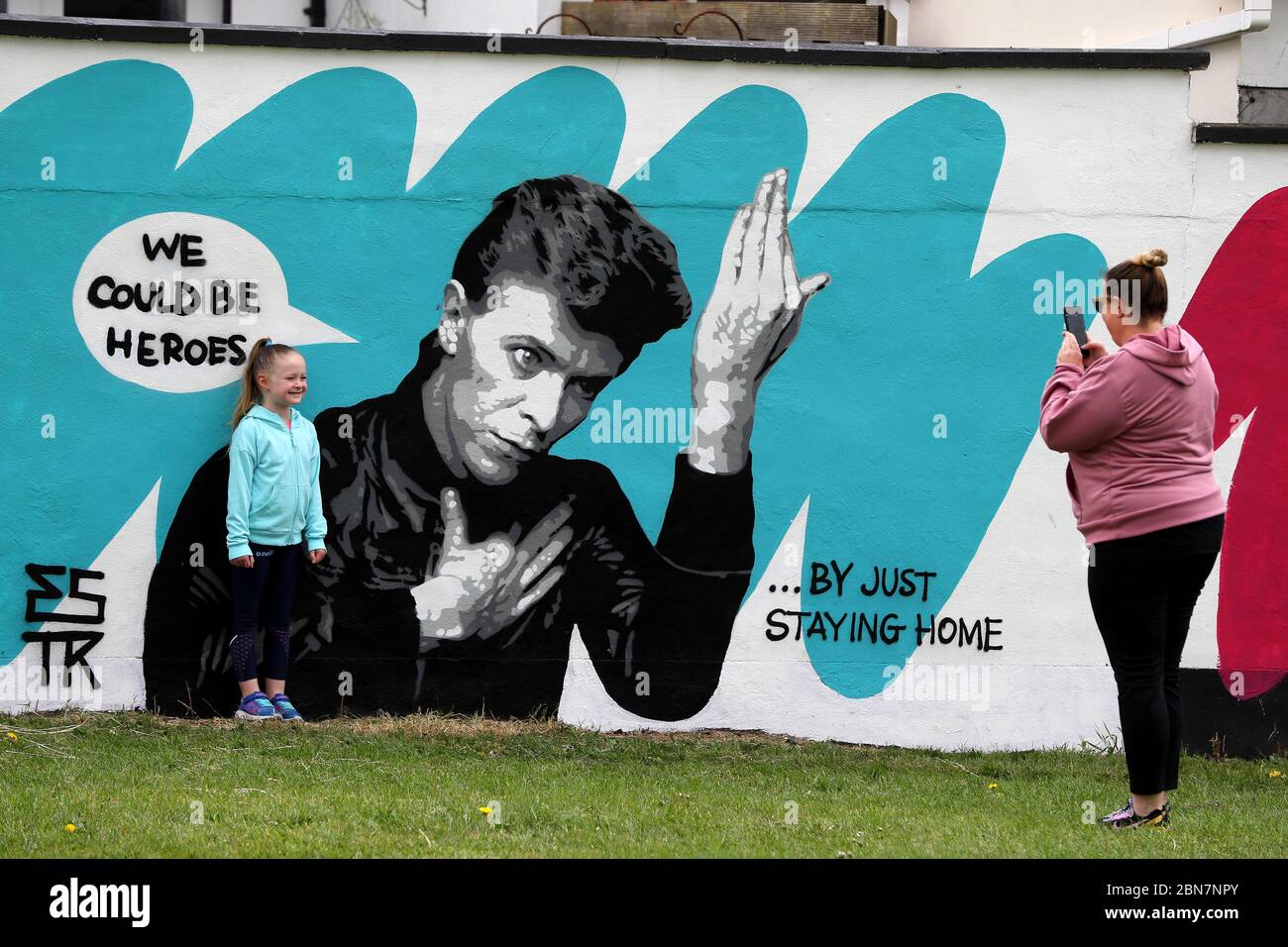 Lorna Mullins et sa fille Penny Mullins (6) prennent des photos avec la fresque de David Bowie, artiste irlandais Emmalene Blake, dans le sud de Dublin. C'est la dernière de la série « Stay at Home » de l'artiste de Dublin qui encourage les gens à s'en tenir à la distanciation sociale. D'autres artistes ont été présentés, notamment Dua Lipa, Robyn et Cardi B. Banque D'Images