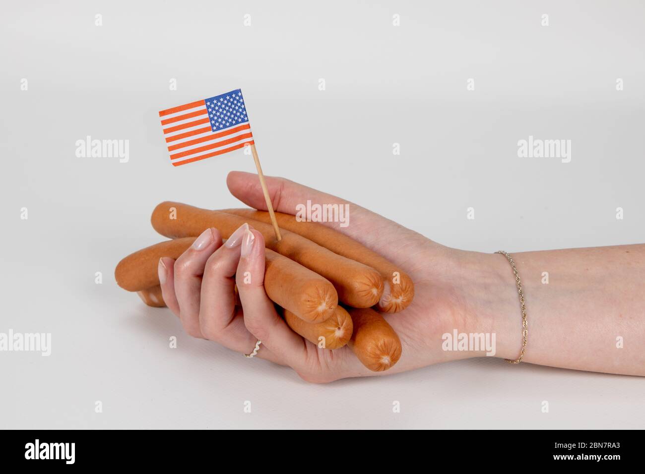 Main féminine tenant des saucisses Wiener avec drapeau américain qui colle  Photo Stock - Alamy