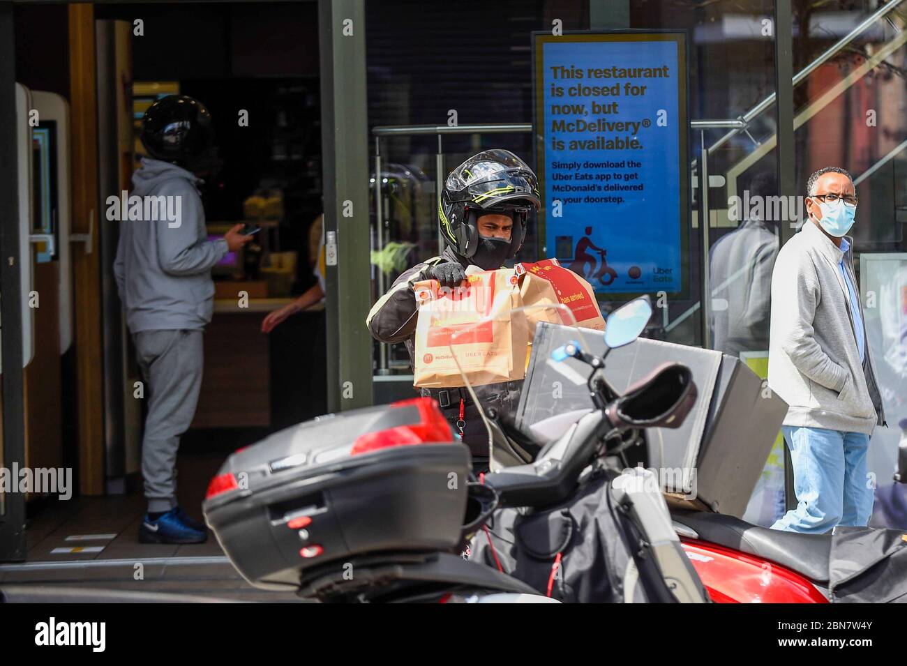 Londres, Royaume-Uni. 13 mai 2020. Un liveur porte sa commande alors que le restaurant de restauration rapide McDonald's de Harrow réouvre pour « MacDelivery » pendant la pandémie de coronavirus. Le restaurant est l'un des 14 au Royaume-Uni que la chaîne rouvre partiellement avec un menu limité et la livraison seulement. La livraison est satisfaite par des tiers tels que Uber Eats et Deliveroo. Credit: Stephen Chung / Alay Live News Banque D'Images