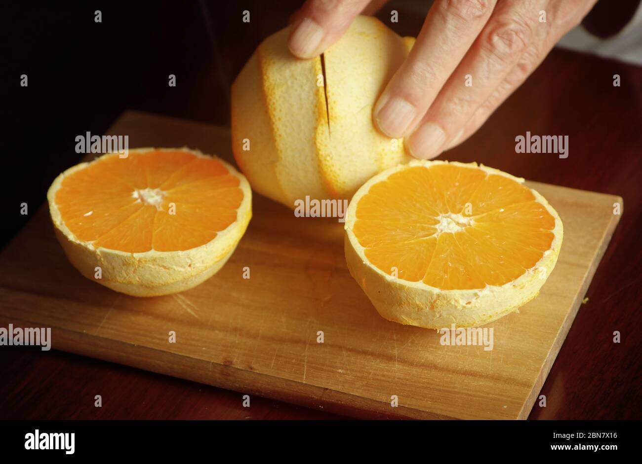 Préparation du jus d'orange : couper les oranges pelées en deux moitiés pour presser le jus Banque D'Images