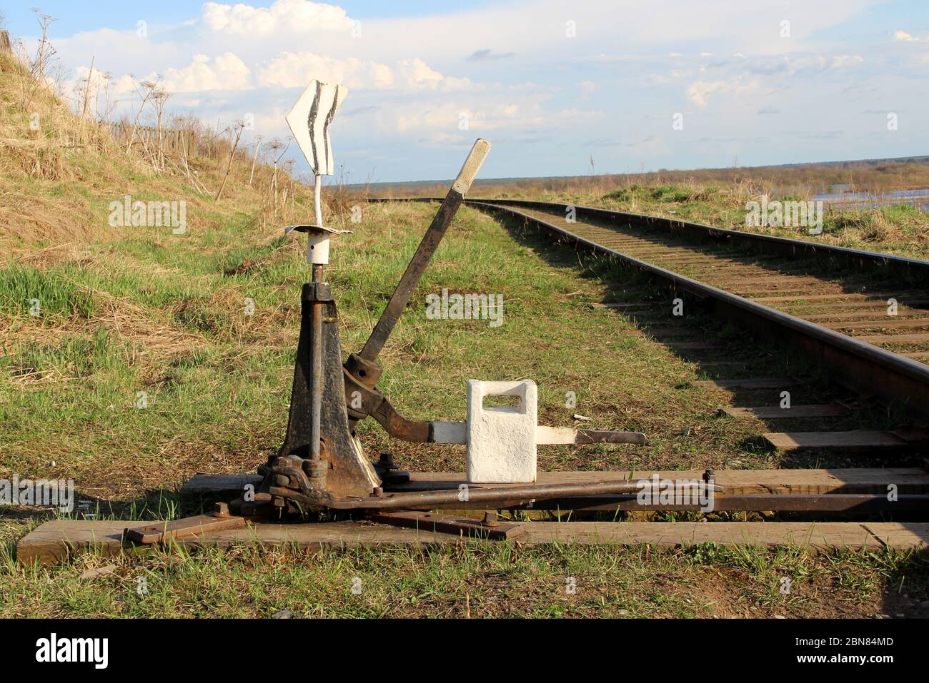 Flèche de chemin de fer en noir avec un levier et un pointeur en Russie. Dispositif de transfert de rails aux intersections pour les trains. Élément technique de l'industrie ferroviaire. Banque D'Images