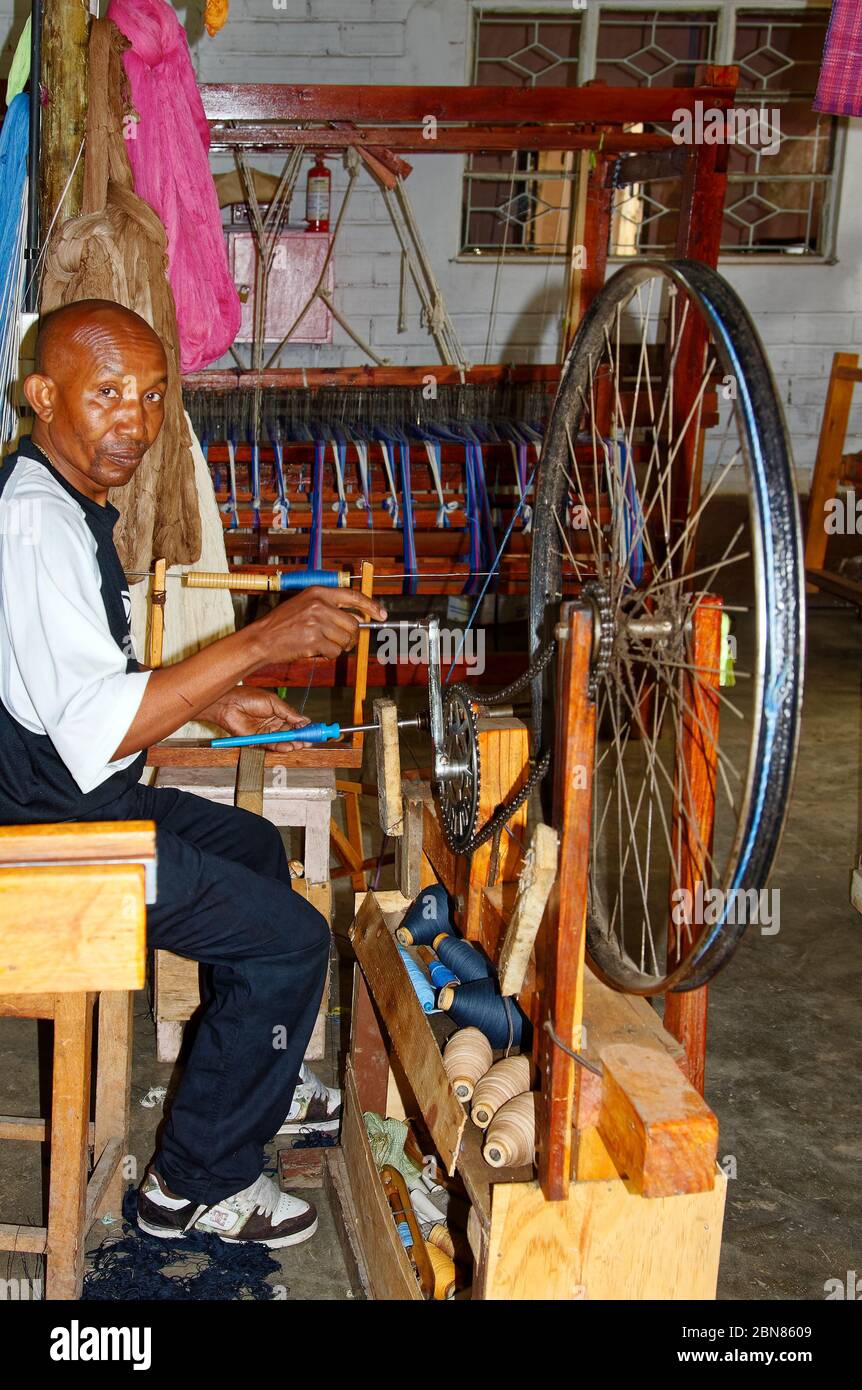 Homme travaillant, roue de vélo tournant à la main, fil de filature, broches de bois, atelier de Shanga River House, entreprise sociale, Arusha; Tanzanie Banque D'Images