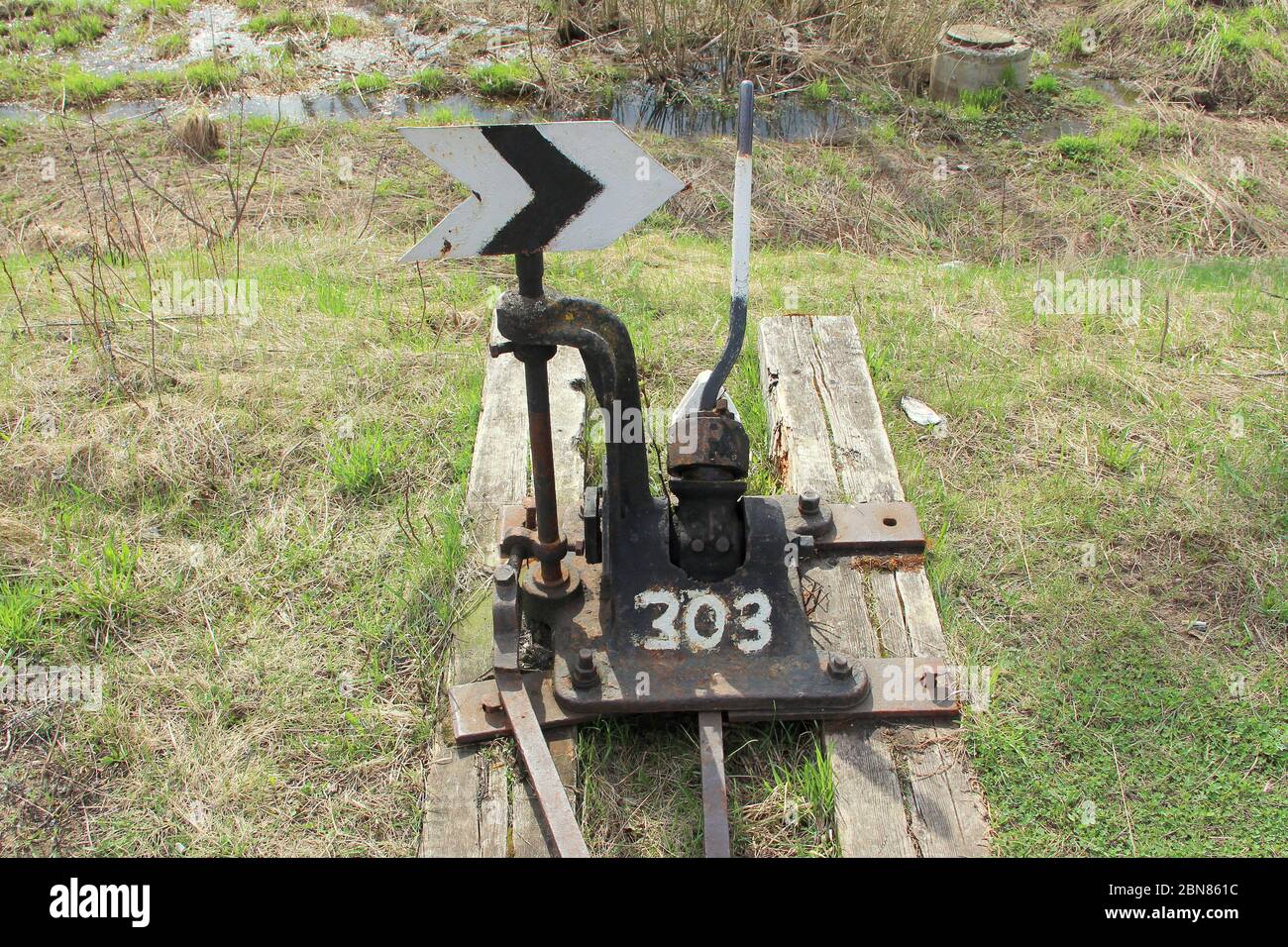 Flèche de chemin de fer en noir avec un levier et un pointeur en Russie. Dispositif de transfert de rails aux intersections pour les trains. Élément technique de l'industrie ferroviaire. Banque D'Images