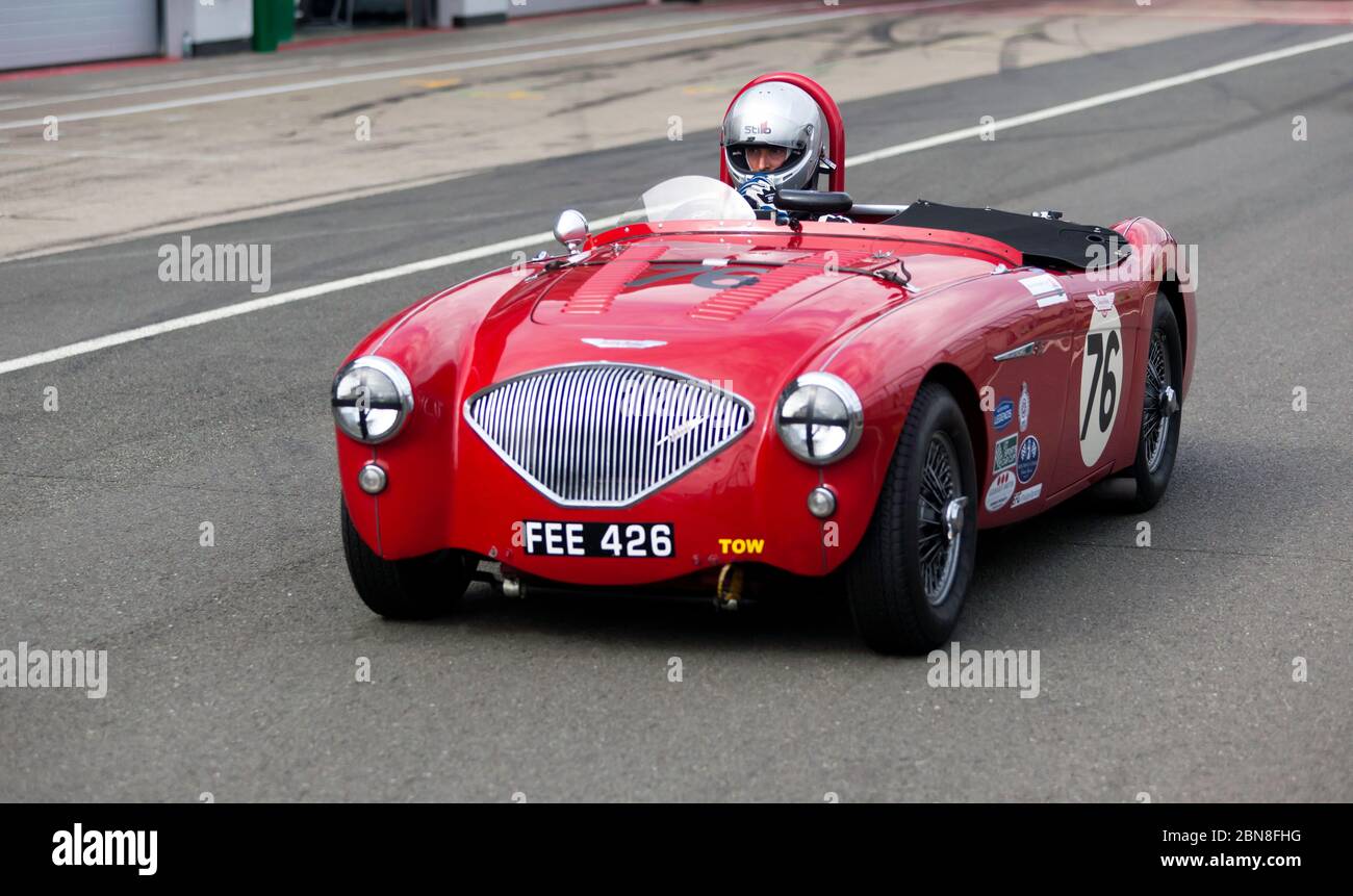 Oliver Harris au volant de son Rouge, 1955, Austin-Healey 100-4, avant la session de qualification pour le Trophée Woodcote RAC pour les voitures de sport pré '56 Banque D'Images
