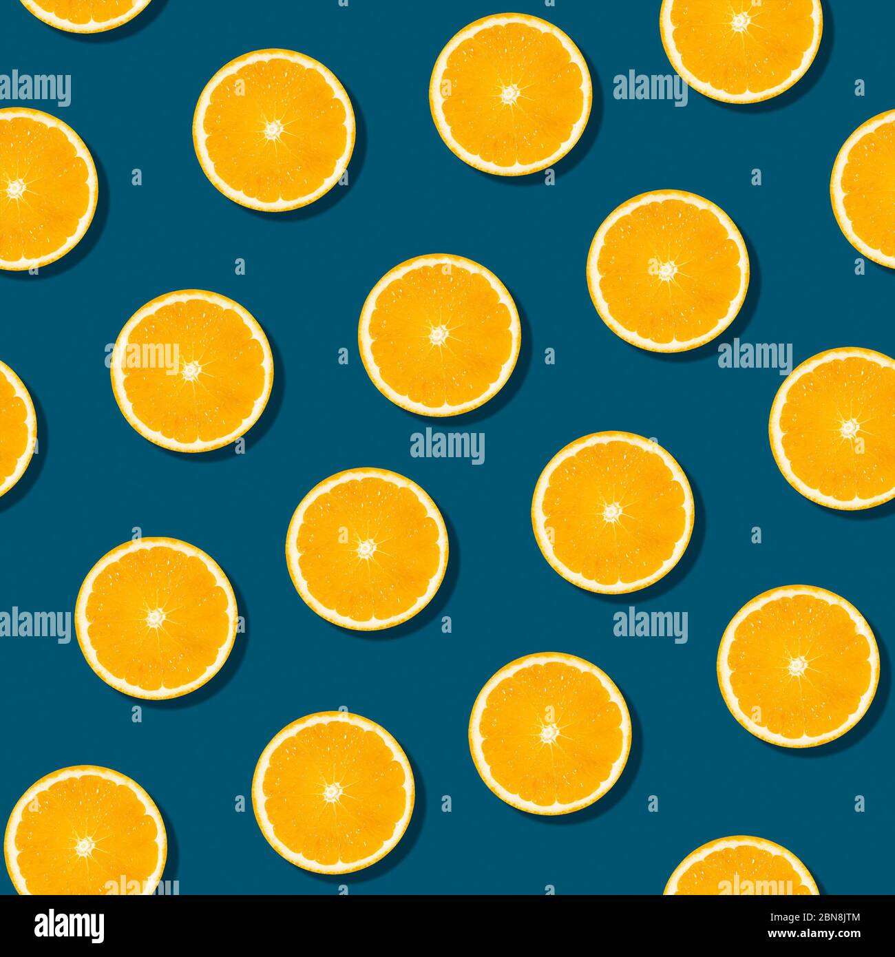 Motif de fruits orange sans couture sur fond bleu. Papier peint en tranches d'agrumes frais et coloré. Couleur créative, concept de frittes d'été. Style minimaliste. Banque D'Images