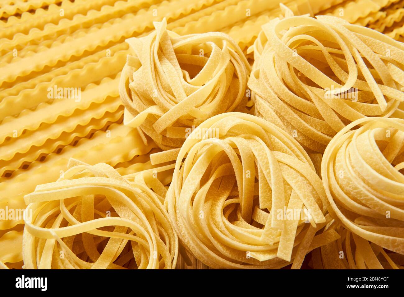 tagliatelle de pâtes sèches et fond doré de mafaldini Banque D'Images