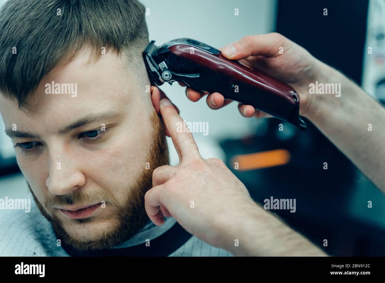 Coupe de cheveux pour hommes avec rasoir électrique. Barber fait une coupe  de cheveux pour le client à la boutique de coiffure en utilisant la  tondeuse à cheveux. Homme coiffant avec rasoir
