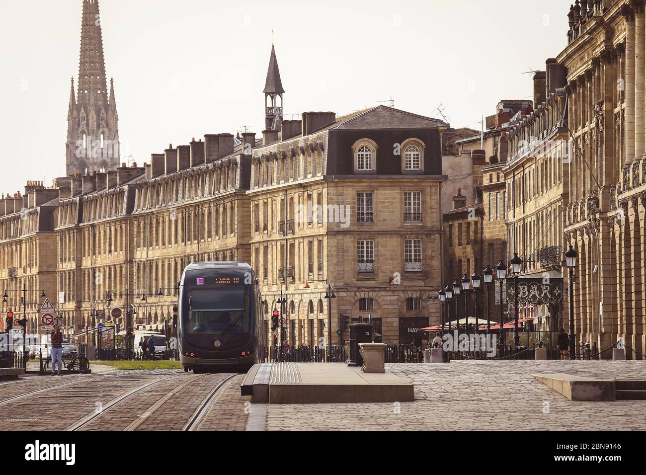 BORDEAUX, FRANCE - 19 JANVIER 2017 : le tramway passe par le centre-ville, la place de la Bourse et l'église Saint-Michel à l'arrière Banque D'Images