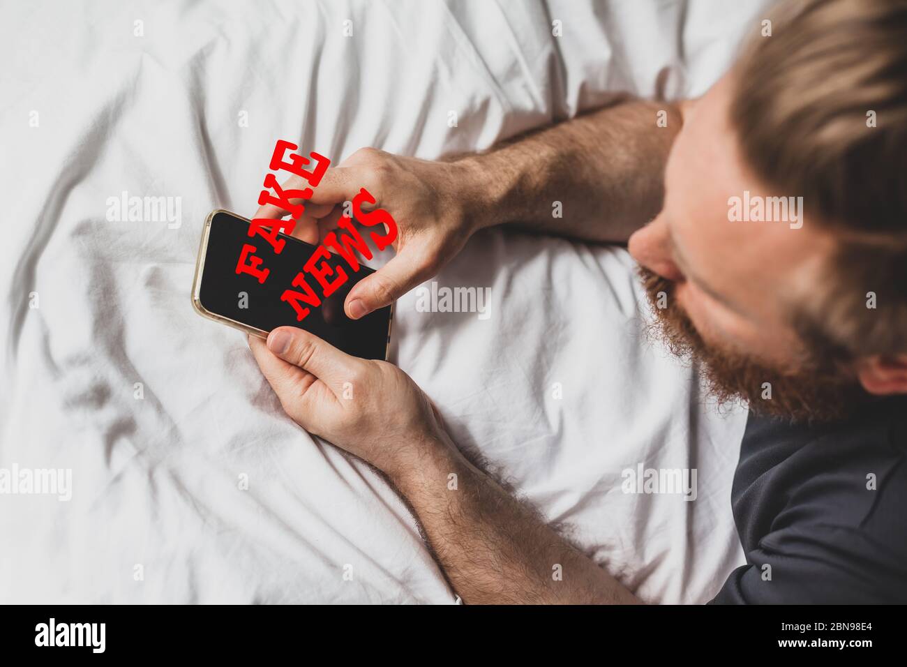 Fausses nouvelles infodemics pendant le concept de pandémie de Covid-19. Les mains de l'homme tenant le téléphone mobile lire les nouvelles mondiales ou le réseau social à la maison. Lire la dernière actualité Banque D'Images