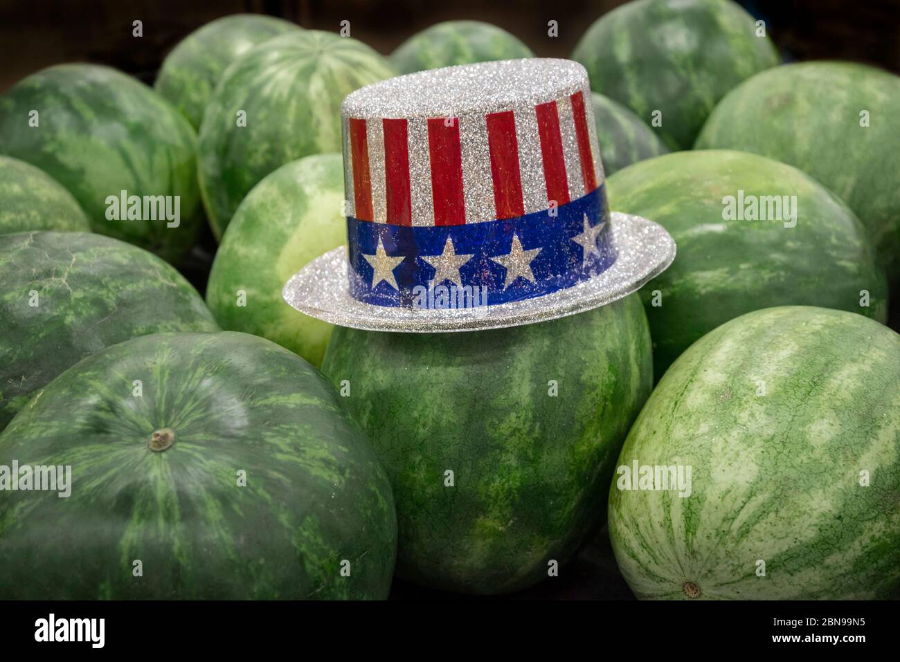 Le chapeau de fête du 4 juillet est situé au-dessus des pastèques pour être vendu dans une épicerie locale en Floride du Nord. Banque D'Images