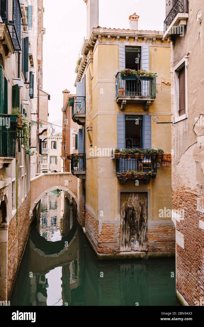 Un canal étroit à Venise. Petits canaux entre maisons, à quelques mètres. De beaux petits ponts entre les rues. Banque D'Images