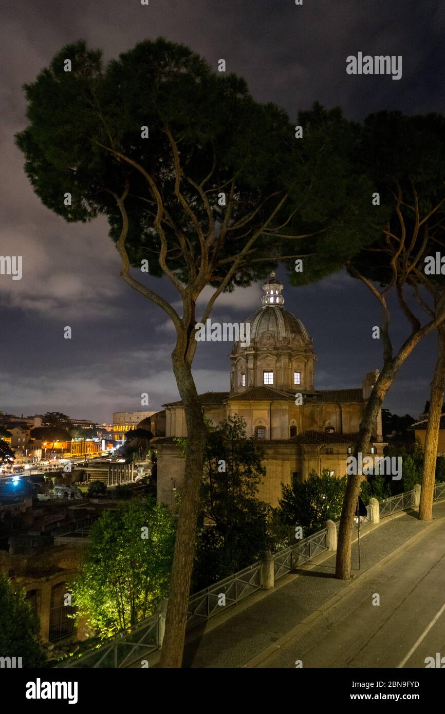 Rome, Italie : Forums impériaux avenue de nuit en arrière-plan et l'église de Sants Luca et Martina sur la droite Banque D'Images
