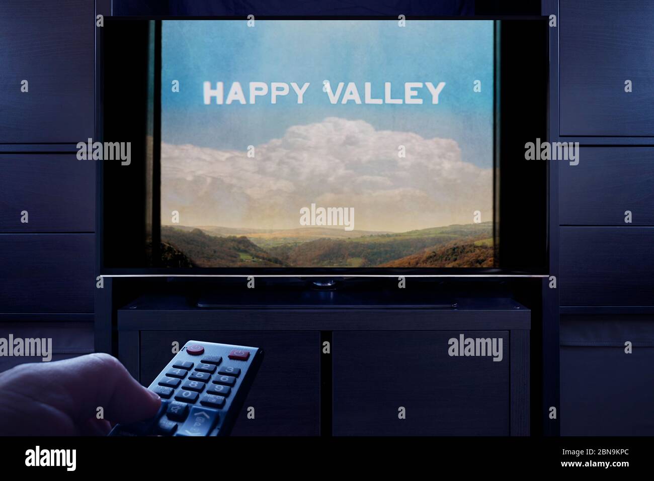 Un homme pointe une télécommande vers le téléviseur qui affiche l'écran principal de Happy Valley (usage éditorial uniquement). Banque D'Images