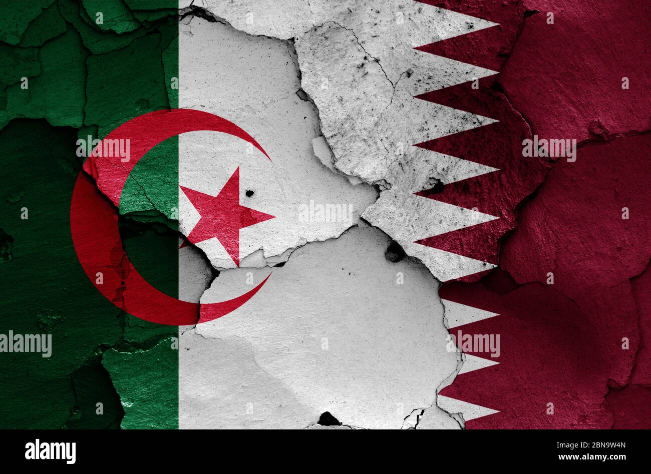 Drapeaux de l'Algérie et du Qatar peints sur un mur fissuré Banque D'Images