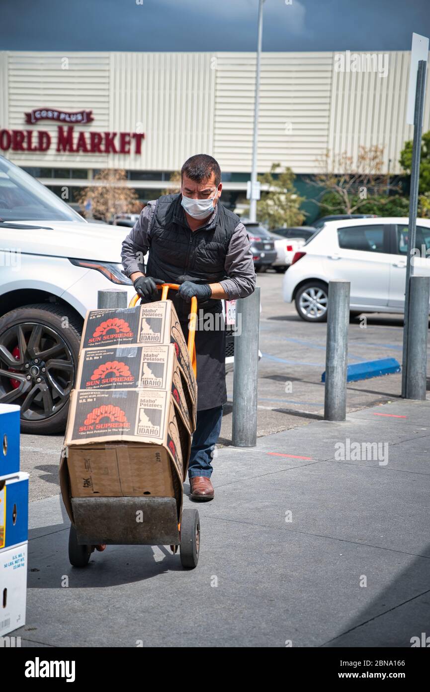 LOS ANGELES, ÉTATS-UNIS - 05 avril 2020 : un membre du personnel du marché agricole qui travaille dur et porte un masque facial pendant l'épidémie de COVID-19. Banque D'Images